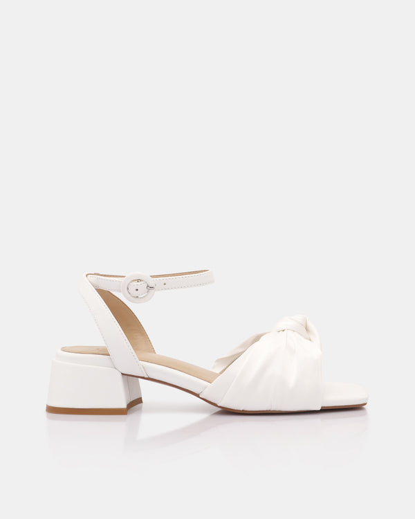 White sandal with a block heel on a white background