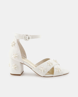 White bridal sandal with floral embellishments on a white background