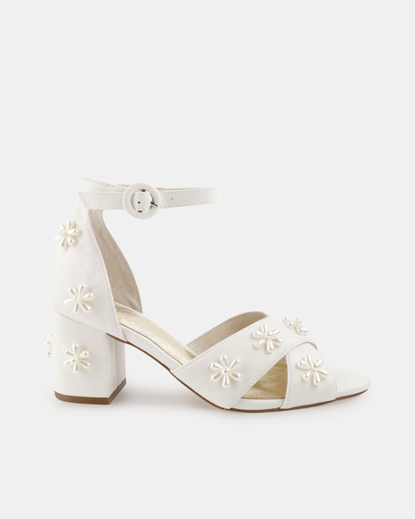 White bridal sandal with floral embellishments on a white background