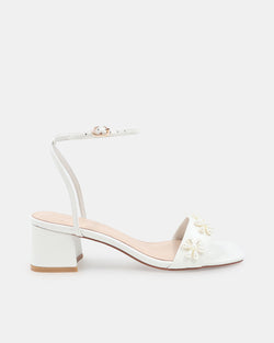 White sandal with floral designs on a white background