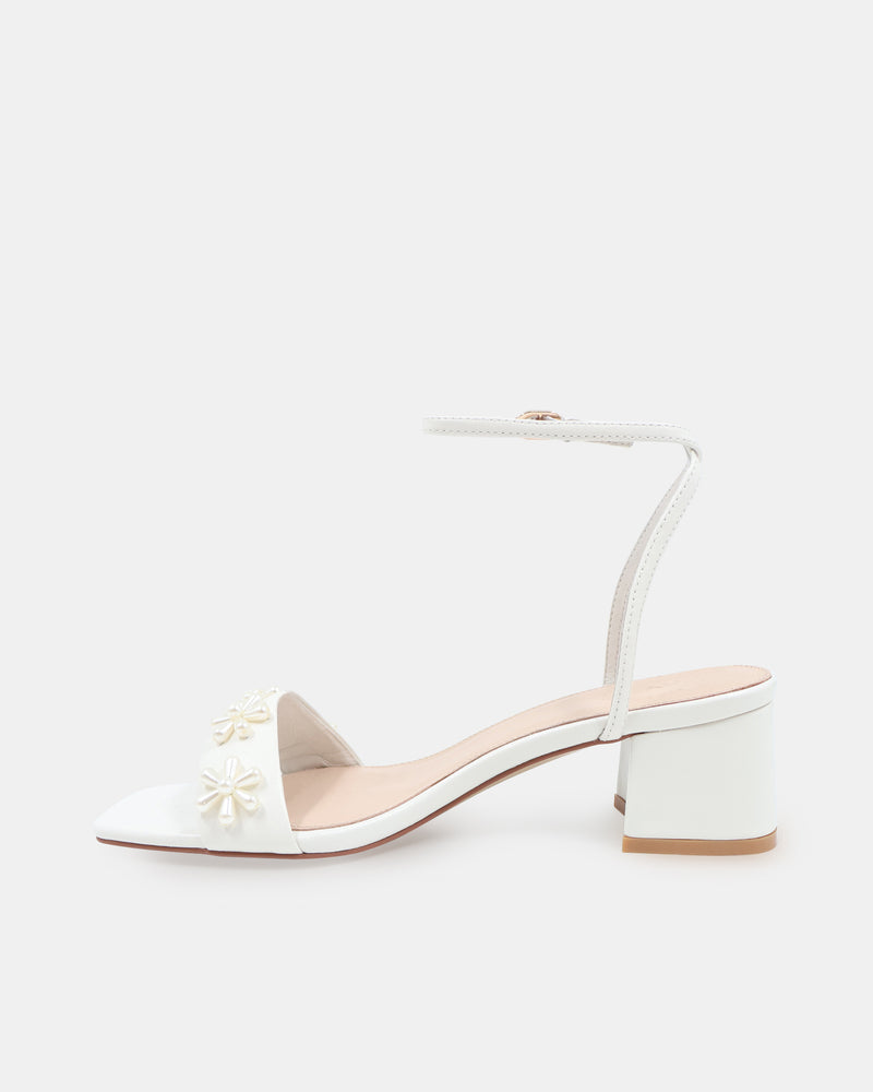 White sandal with floral designs on a white background