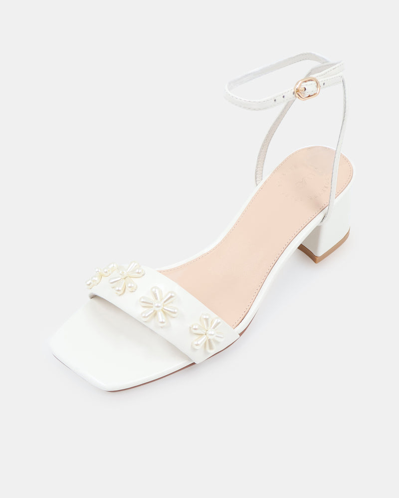 White sandal with floral designs on a white background