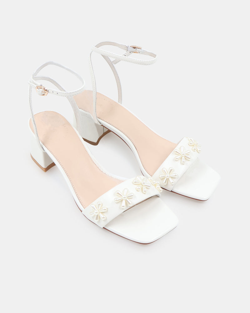 White sandal with floral designs on a white background