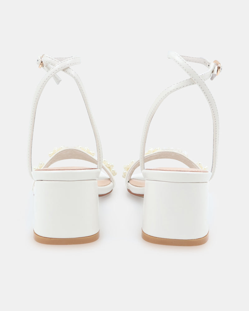 White sandal with floral designs on a white background
