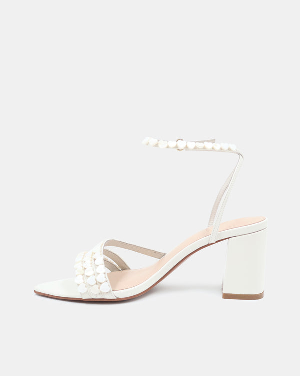 White sandal with pearl details on a light gray background