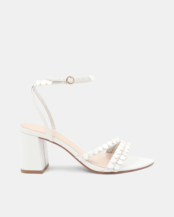 White sandal with block heel and ankle strap on a light gray background