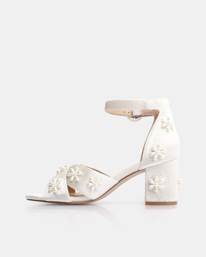 White sandal with floral cutouts on a white background