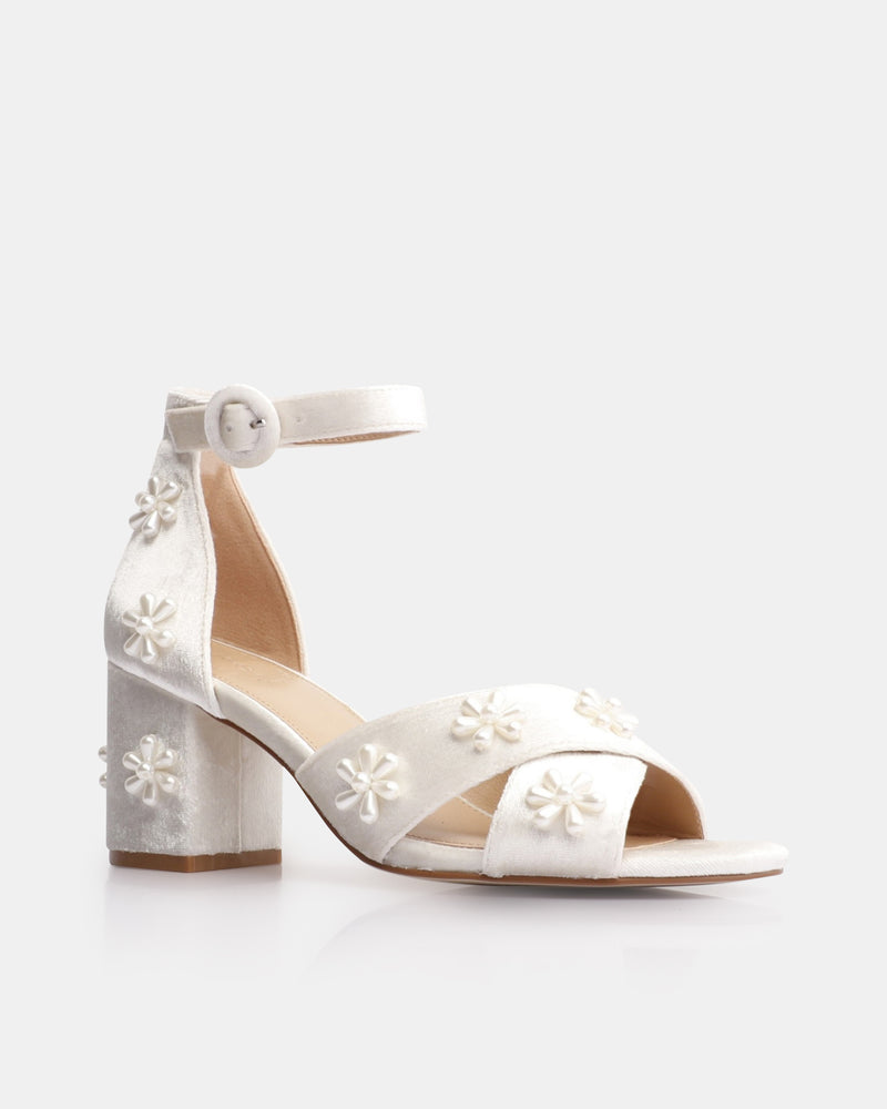 White sandal with floral designs on a white background