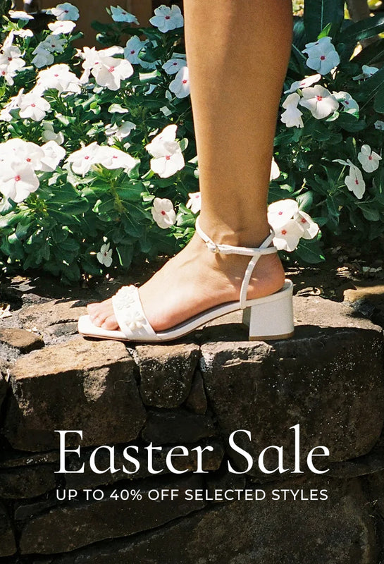 White sandal on a stone step with flowers in the background, Easter Sale text overlay.