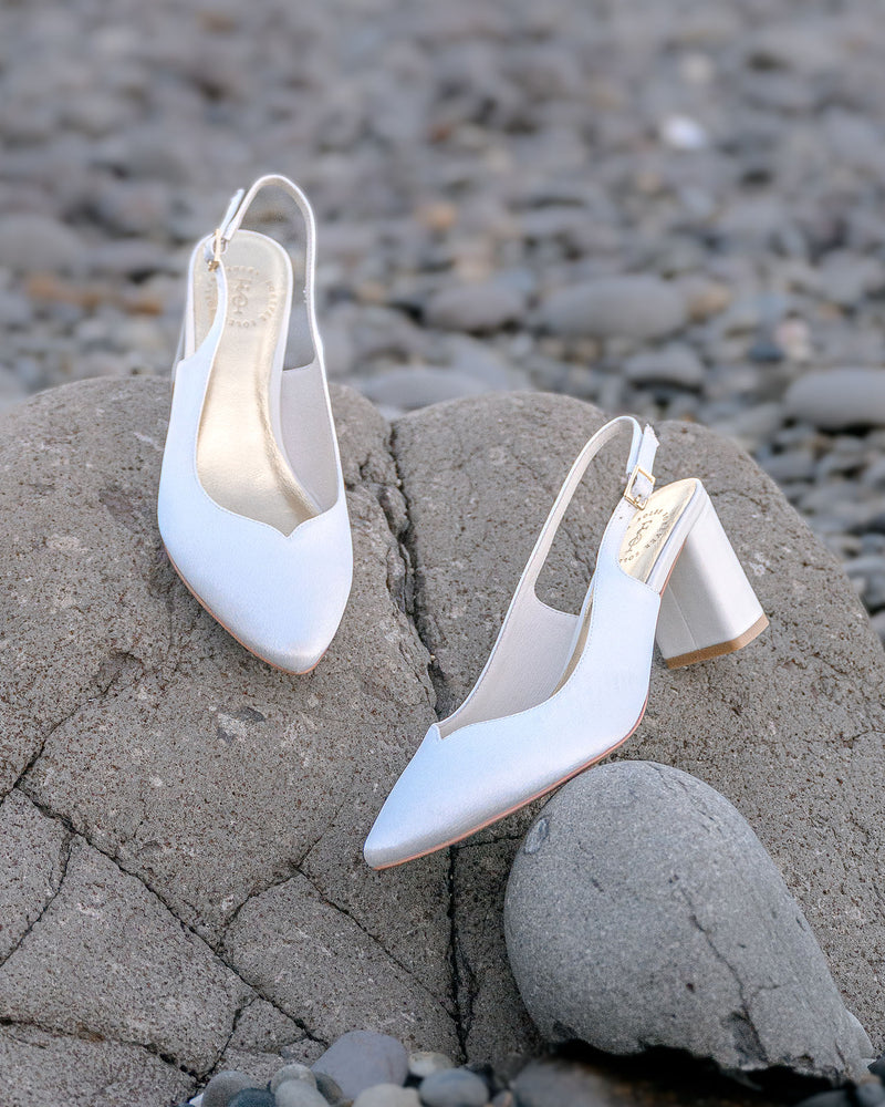 White high-heeled shoes on a rocky surface