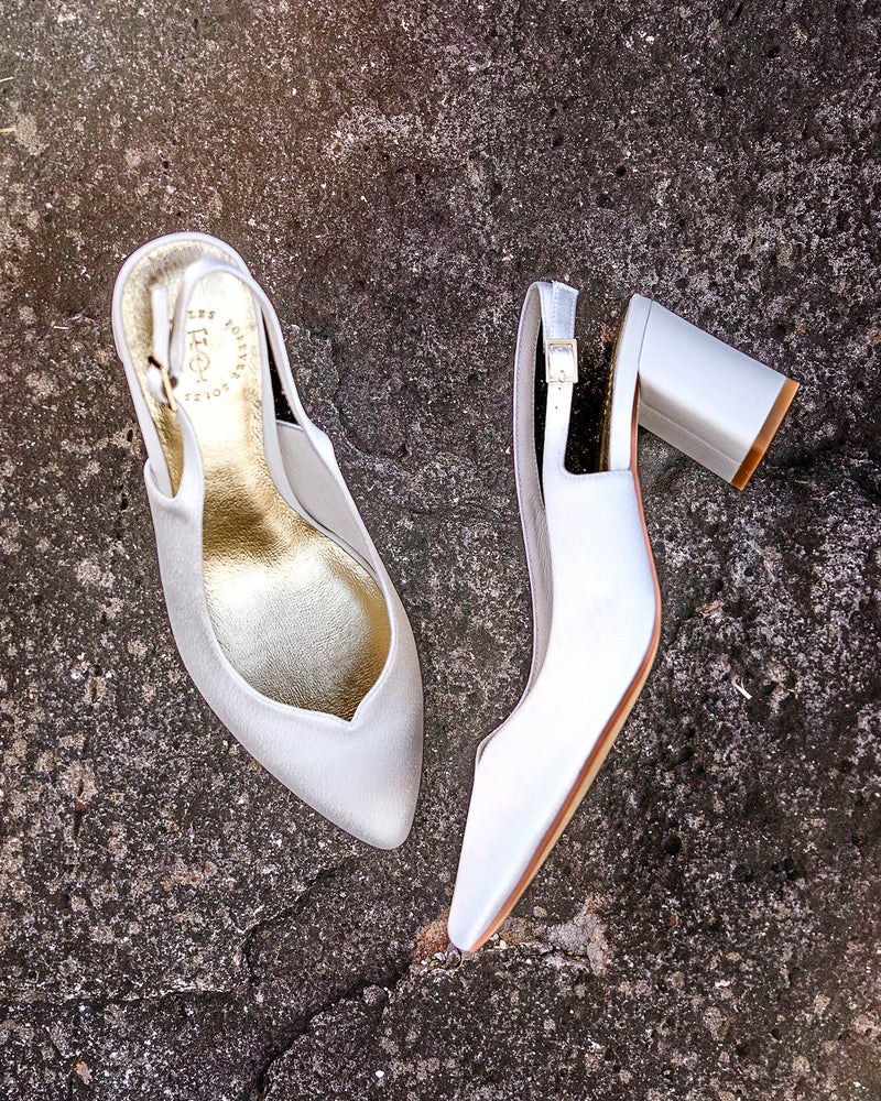 White high-heeled shoes on a textured surface