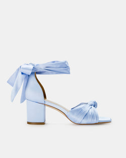 Light blue high-heeled shoes with ribbon details on a white background