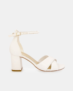 Ivory bridal sandal with block heel and pearl ankle strap on a white background