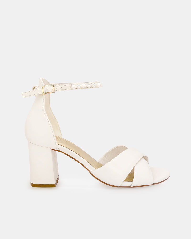 Ivory bridal sandal with block heel and pearl ankle strap on a white background
