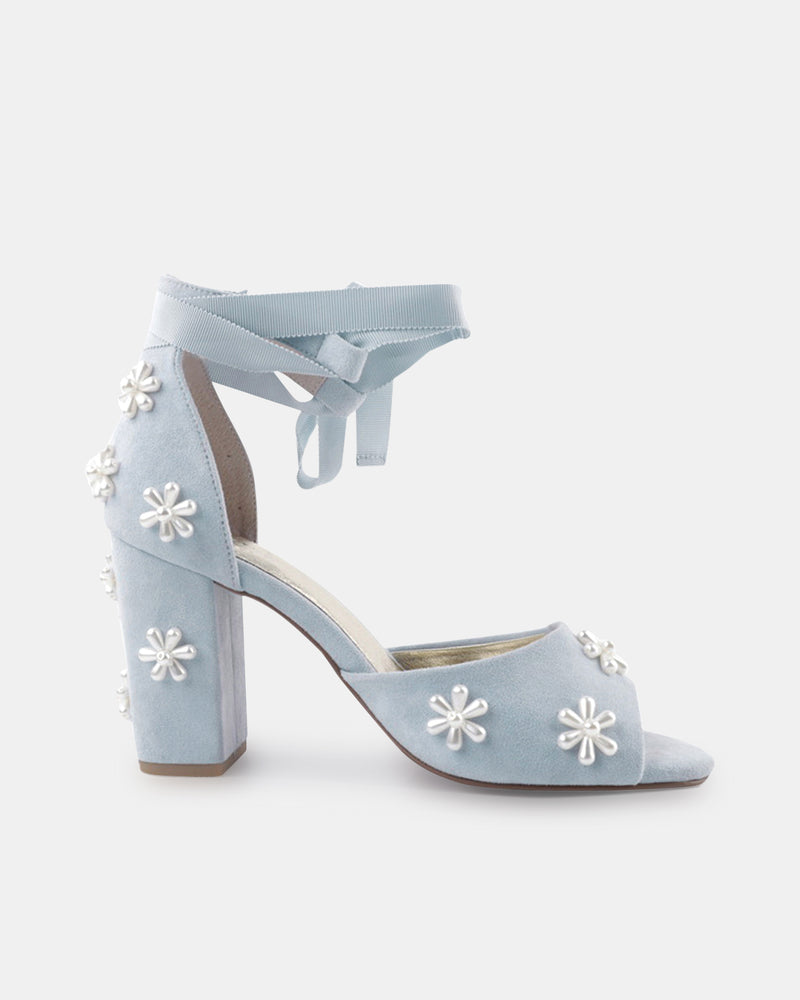 Light blue high-heeled shoes with floral embellishments on a white background