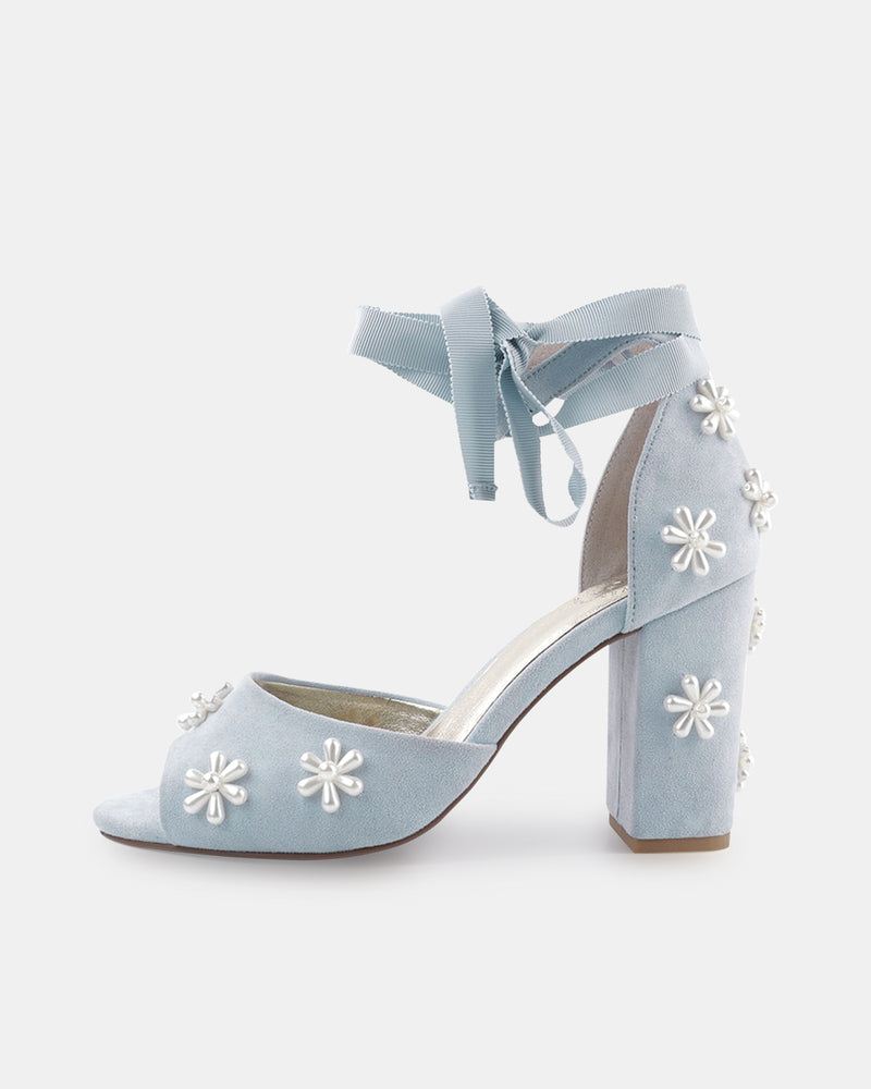 Light blue high-heeled shoes with floral embellishments on a white background