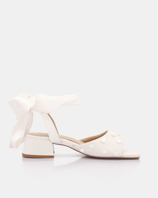 White shoes with bow detail on a white background