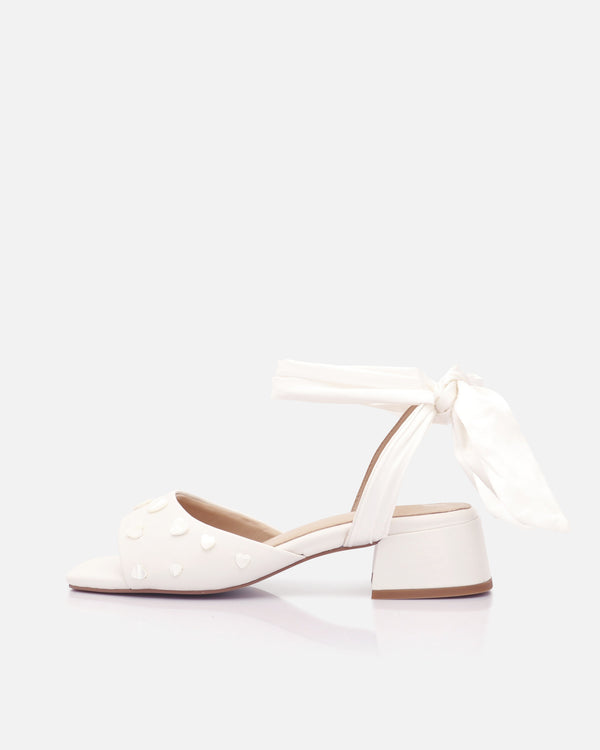 White shoes with ankle strap on a light gray background
