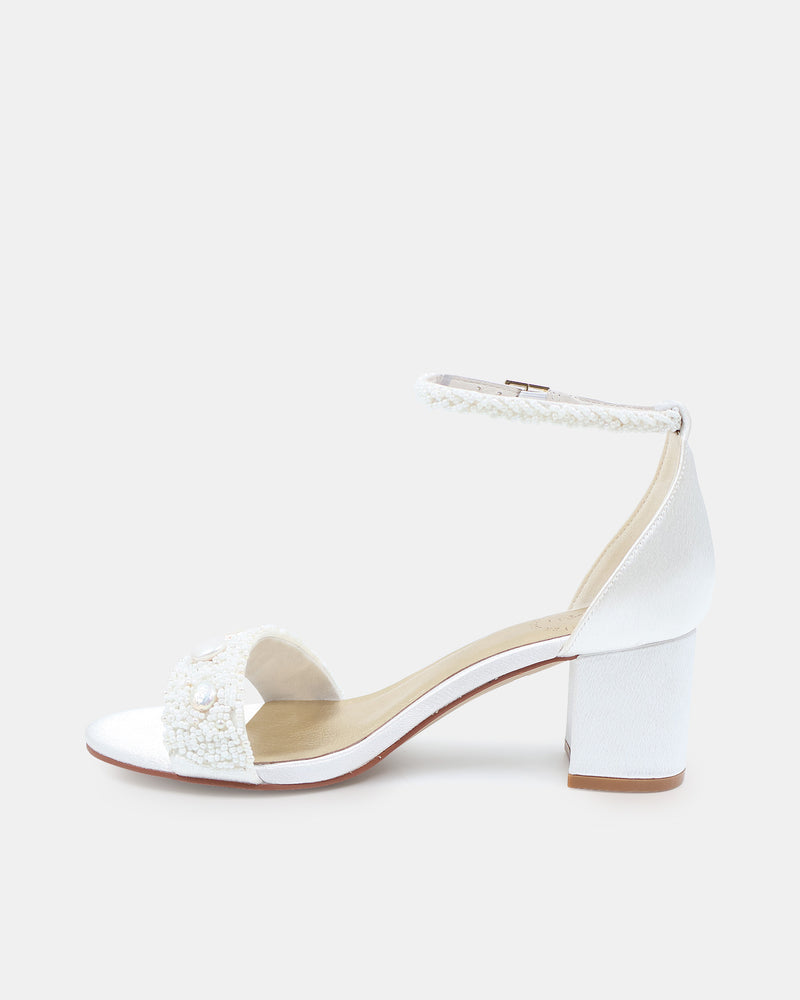 White shoe with decorative elements on a light gray background