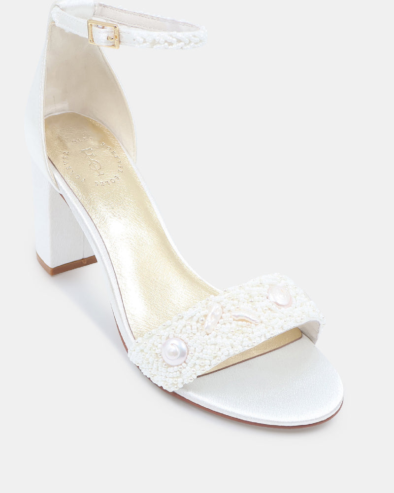 White sandal with pearl embellishments on a white background