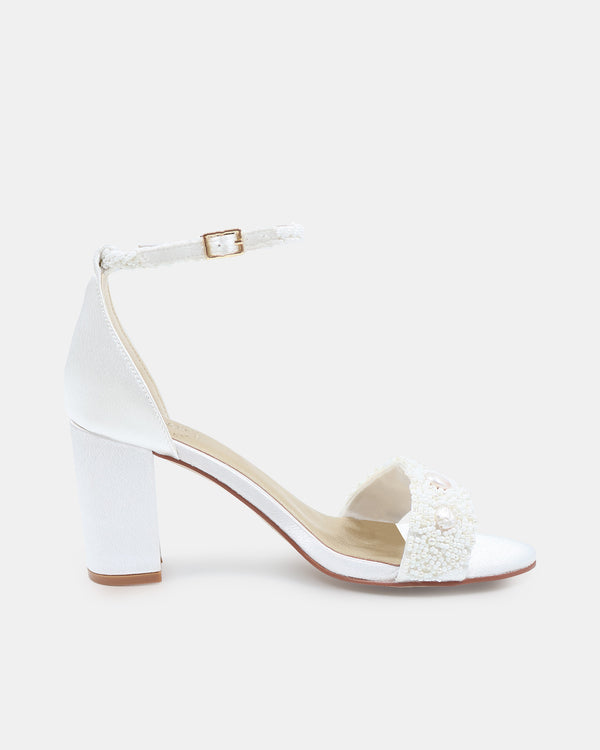 White sandal with block heel and decorative bow on a white background