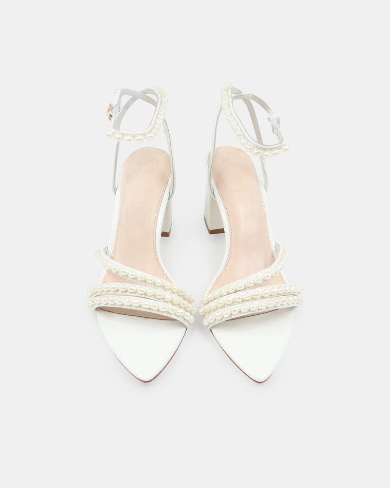 White high-heeled shoes with clear straps on a white background