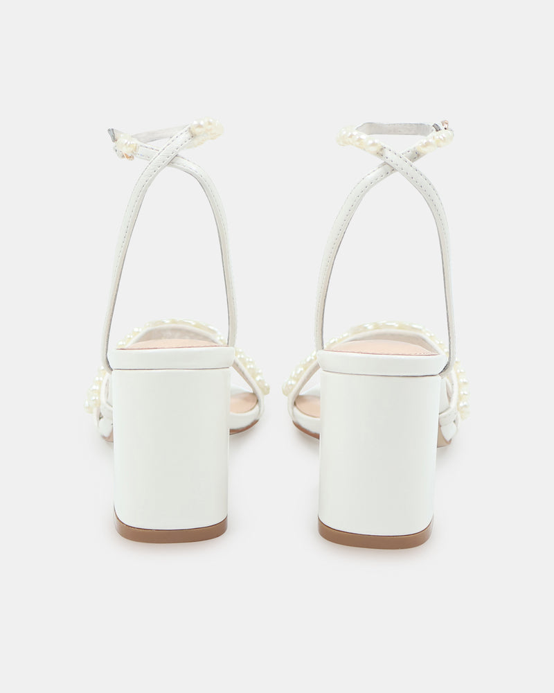 White high-heeled sandals with thin straps on a white background
