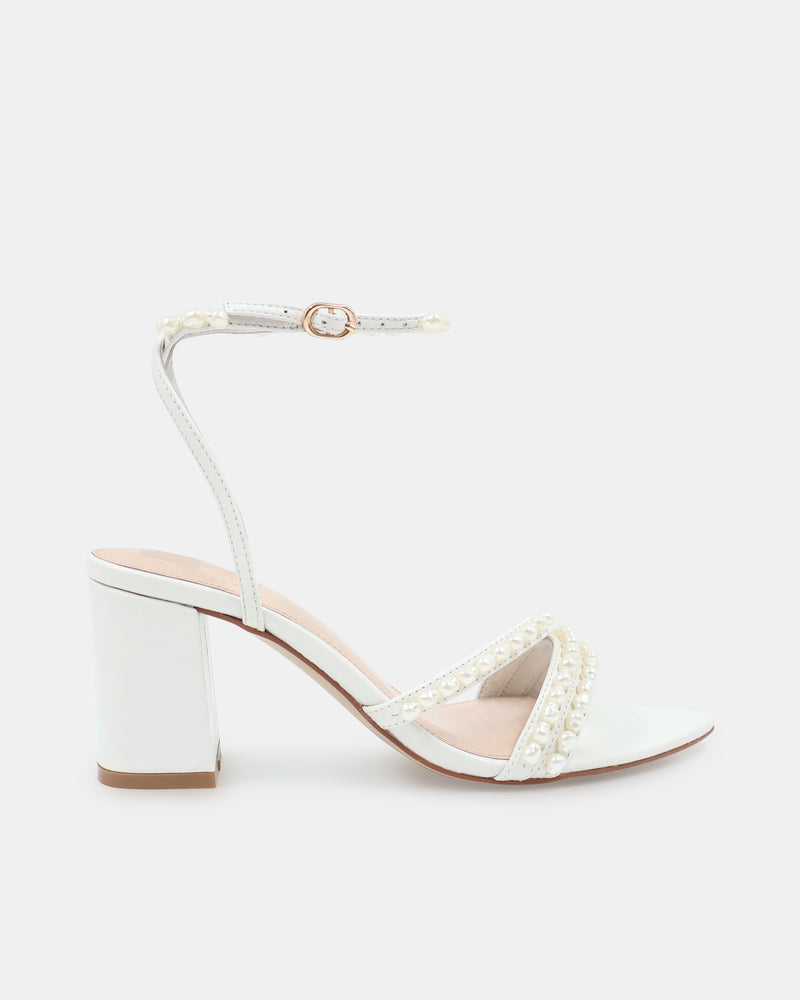 White sandal with block heel and ankle strap on a light grey background