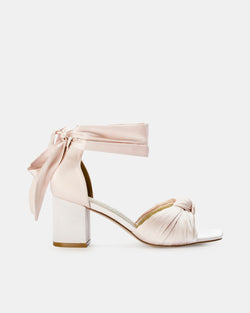 Nude block-heel shoes with ribbon detail on a white background