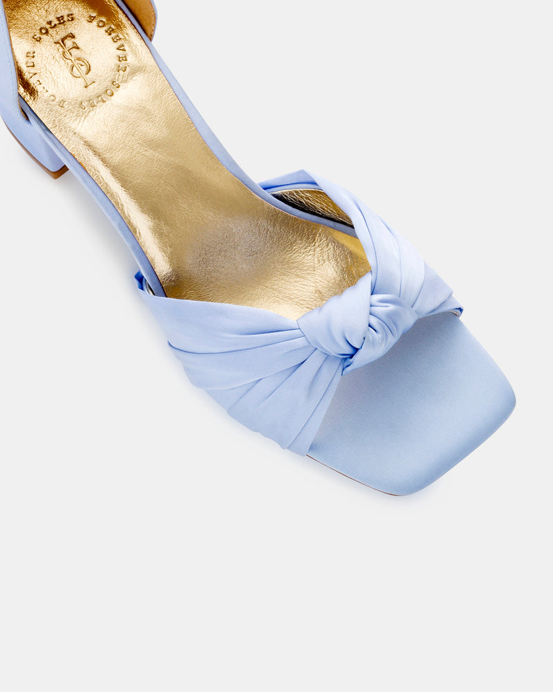 Light blue high-heeled shoes with ribbon details on a white background